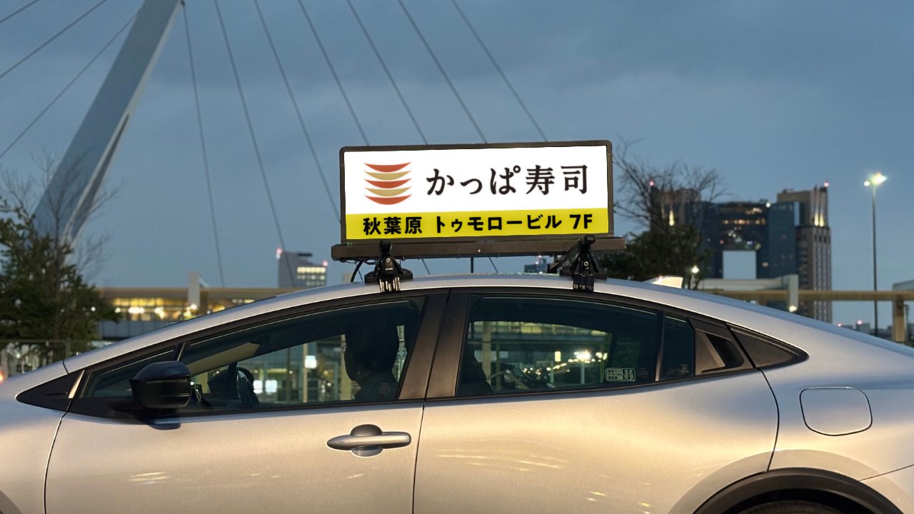 かっぱ寿司 秋葉原トゥモロービル7Fの広告を屋根のデジタルサイネージに表示した車両
